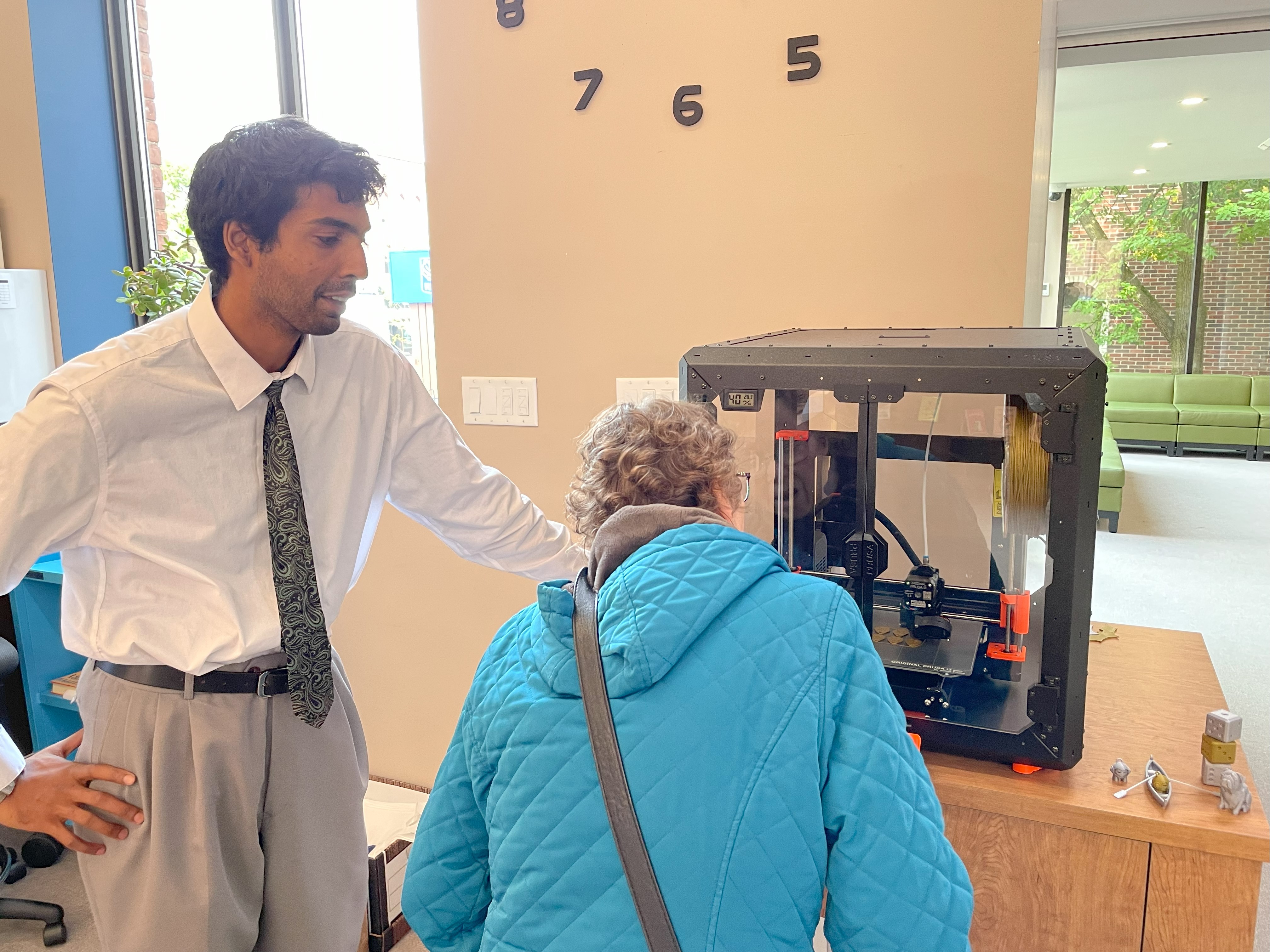 Raghav Patel demonstrating 3D printer to a customer